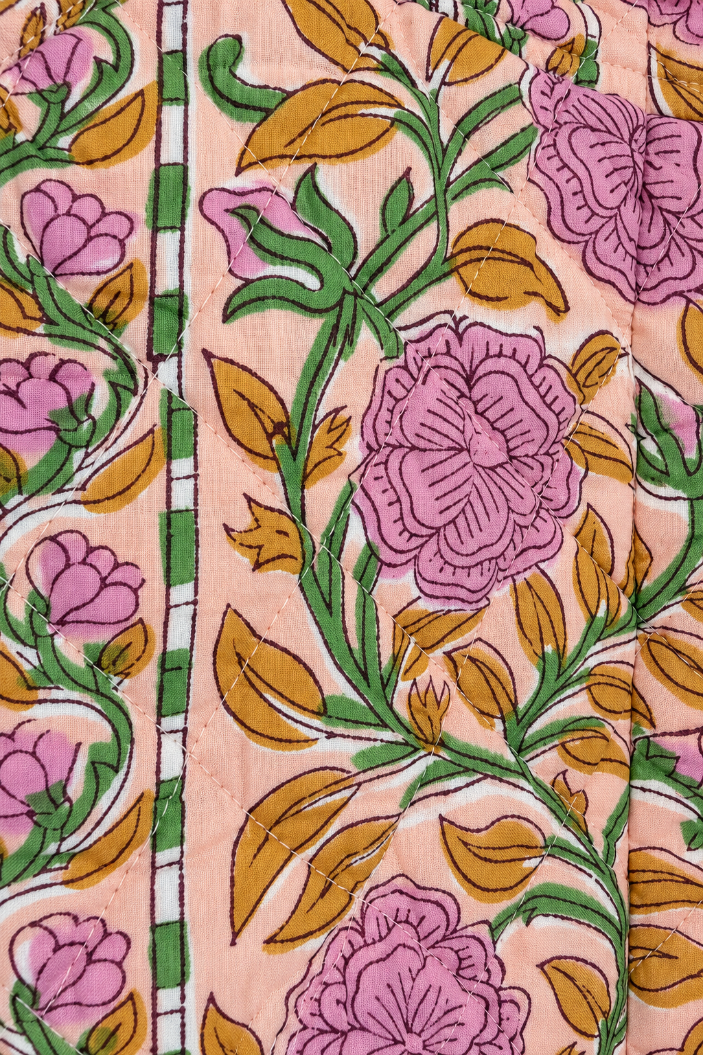 A close-up of a printed textile pattern featuring pink flowers, green stems, and mustard-yellow leaves on a light peach background.