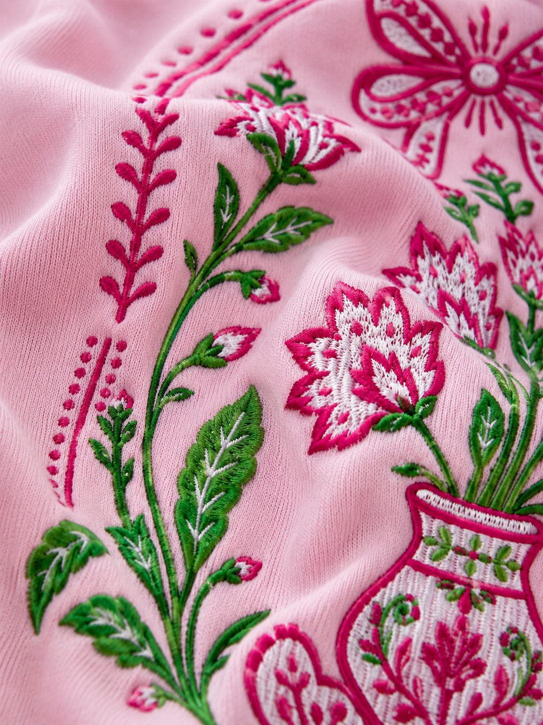 Close-up of pink fabric with intricate floral embroidery